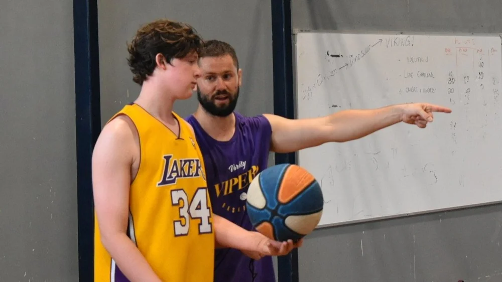 A Vipers coach talking a player through a play at the whiteboard
